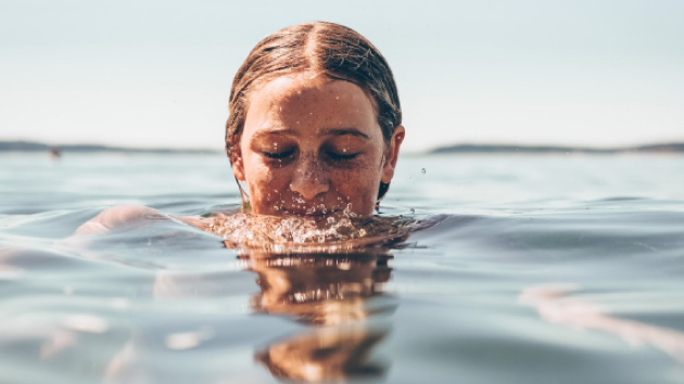 Photo d'une femme qui se baigne avec la tête qui sort de l'eau