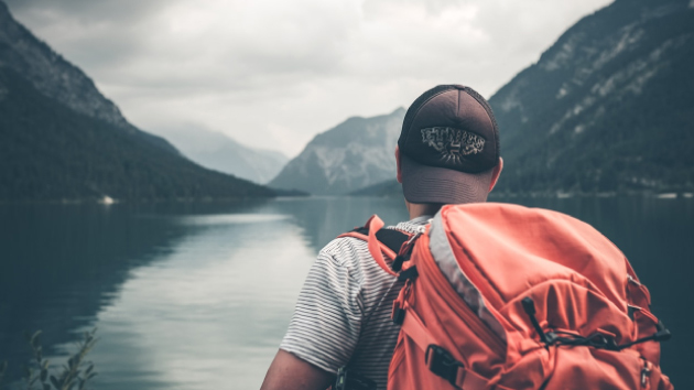 Photo de dos d'un randonneur devant un lac