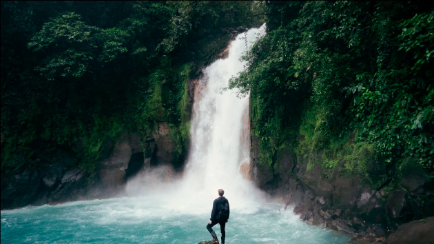 Photo d'une personne devant une cascade d'eau